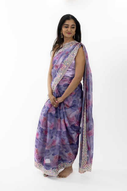 A full view of the “Radiance Silk Saree” in a captivating purple hue, adorned with floral patterns. The saree’s premium silk fabric is luxuriously soft and smooth, providing a comfortable and flattering fit. The rich purple color evokes a sense of royalty and grandeur, perfect for creating a refined look. This ready-to-wear saree is ideal for grand occasions in Australia.