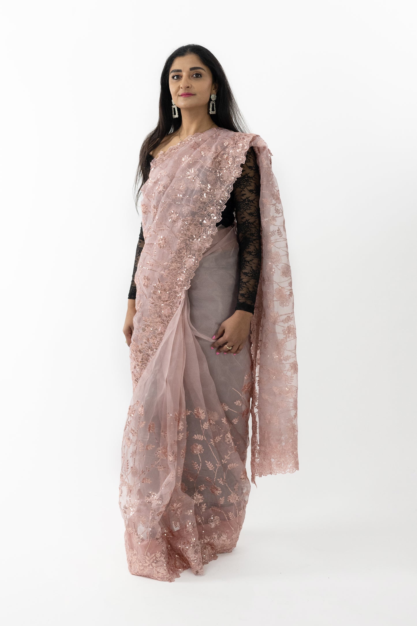 The image captures a person showcasing the beautiful drape of the ready-to-wear peach organza saree in Australia. The saree’s intricate detailing and light, airy fabric create a graceful and sophisticated appearance. Ideal for weddings, receptions, and festive celebrations, this saree exudes timeless beauty and elegance.