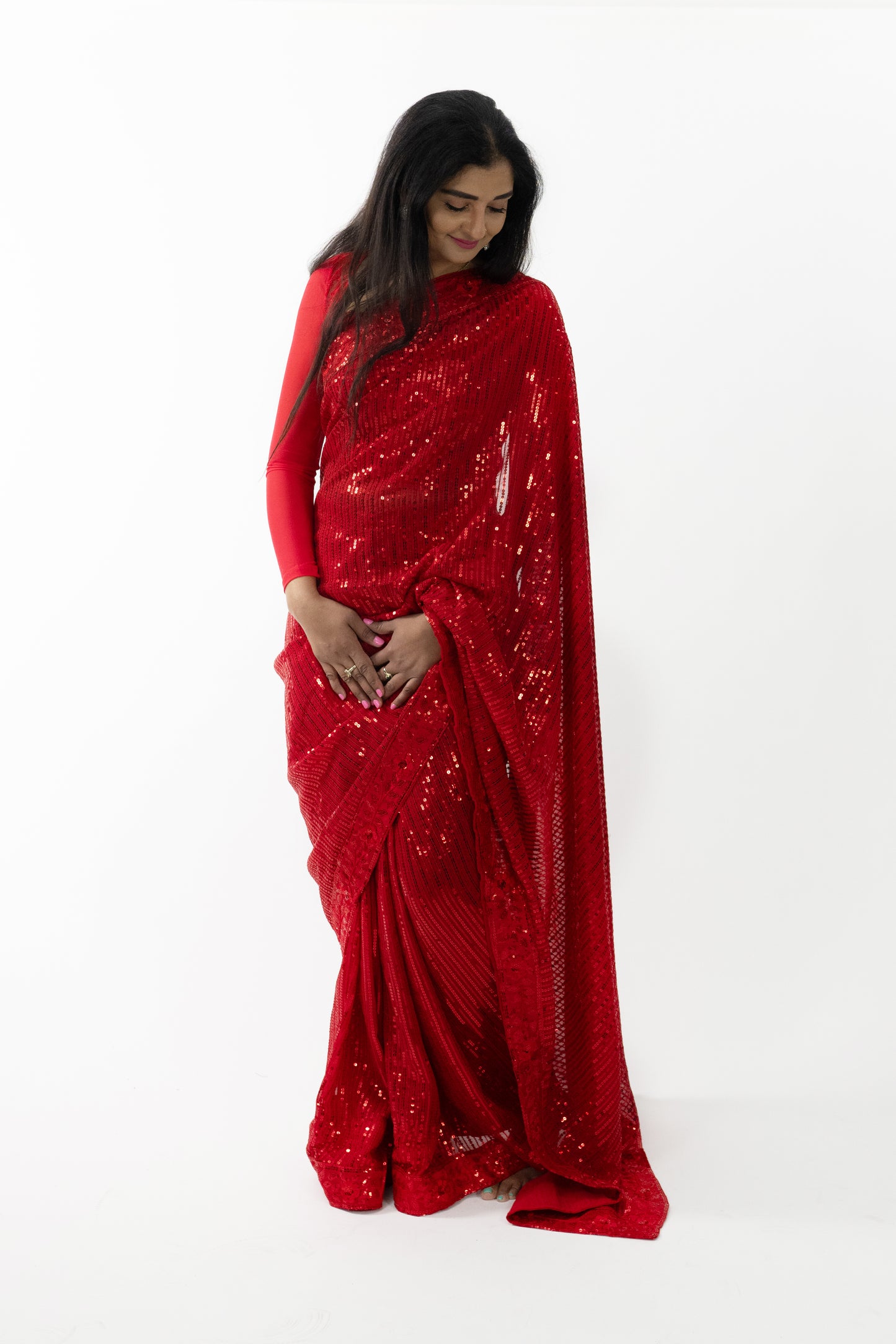 the image captures a person showcasing the beautiful drape of the ready-to-wear red georgette saree in Australia. The saree’s sparkling details and soft, flowing fabric create a graceful and sophisticated appearance. Ideal for weddings, receptions, and festive celebrations, this saree exudes timeless beauty and elegance.